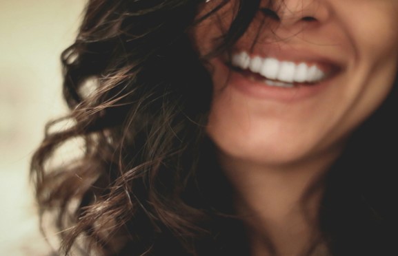 Woman smiling after subperiosteal dental implant procedure